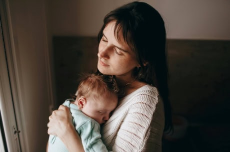 Young mom with a baby wresting with postpartum intrusive thoughts